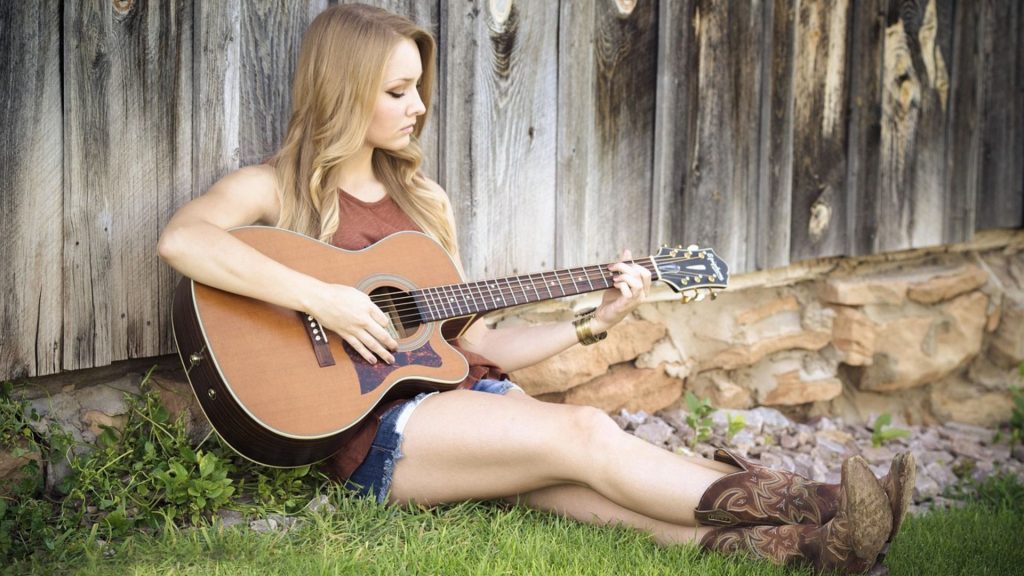 Best Acoustic Guitars Under $1000 women playing guitar